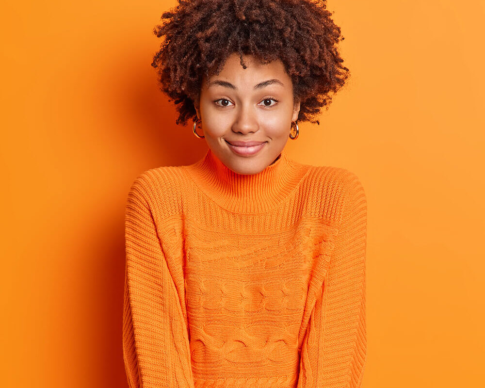 portrait-of-satisfied-curly-haired-woman-wears-cas-EJXSG62.jpg