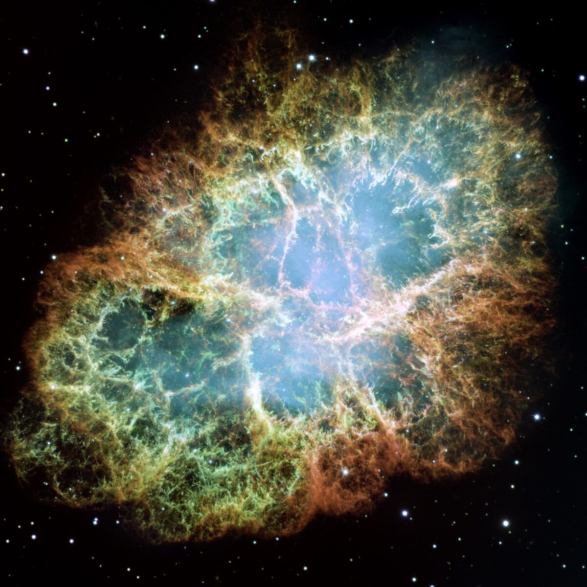 The Crab Nebula, orange and red threads of gas around a blue-white heart