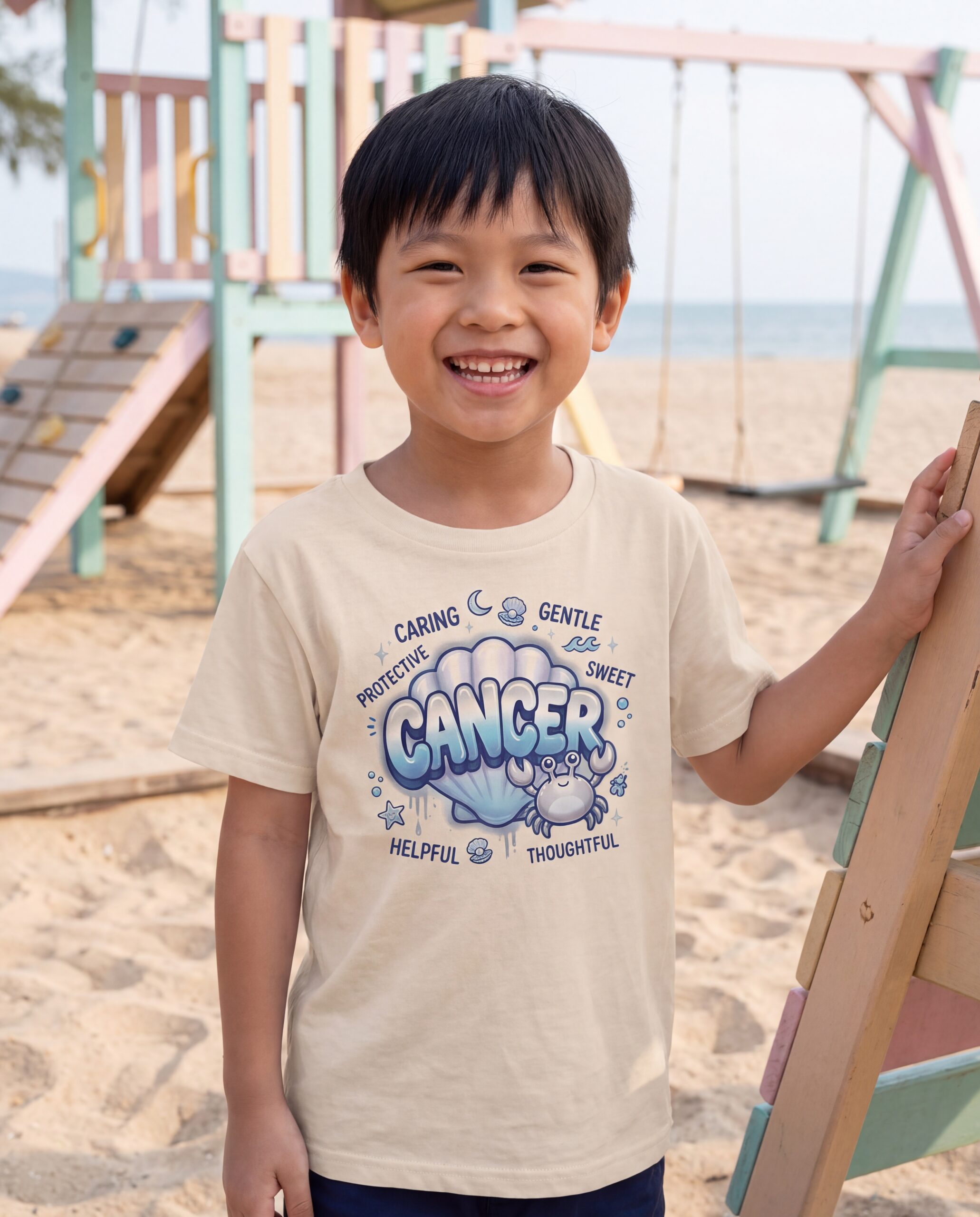cancer-aries-street-sign-scorpio-street-sign-tail-badge-youth-tee-natu-2026-10-27-01-0b3809.jpg Cancer Aries: Street Sign × Scorpio: Street Sign Tail Badge Youth Classic Tee (Gildan 5000B), Natural, White in use: A beachside children's playground with a sandpit and pastel play equipment, soft sea-breeze daylight.
