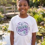 Pisces Aries: Street Sign × Scorpio: Street Sign Tail Badge Youth Classic Tee (Gildan 5000B), White, Sport Grey in use: A sunny garden pond with lily pads and a small wooden footbridge, dappled afternoon light, soft pastel colours.